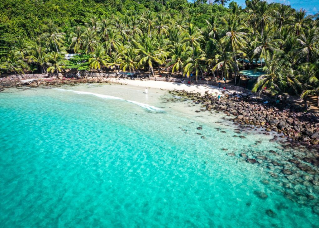 A rocky cove and blue waters with lush greenery on Phu Quoc Island