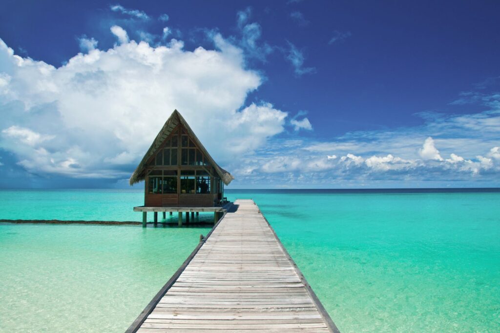 Beach cottage over the water with boardwalk and clear waters in the Philippines