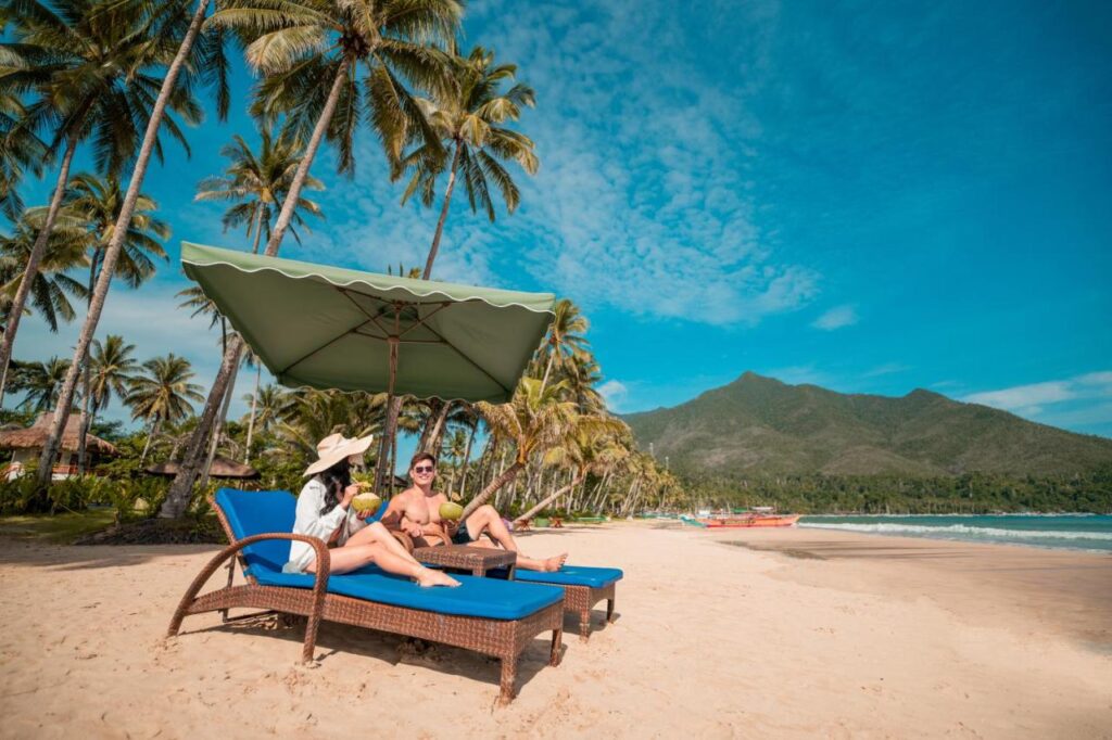 couple sitting on a lounge at the beach in Puerto Princesa