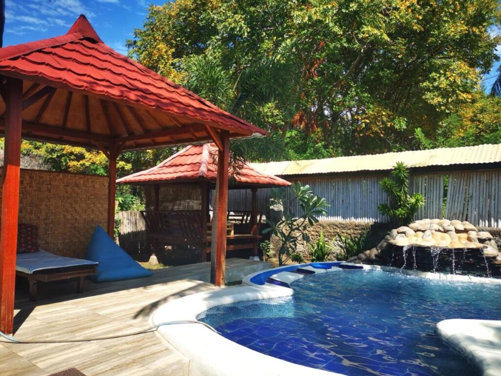 small crystal clear pool beside a cottage