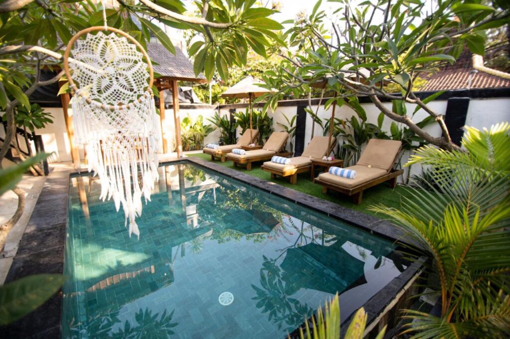 private pool with tropical design and deck chairs