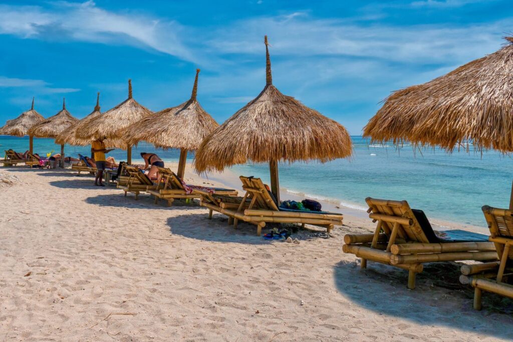tourists relaxing on the native beach huts on the beach