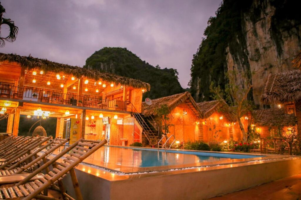 warm lights and an outdoor pool at Tam Coc Wonderland Bungalow with the background of a mountain