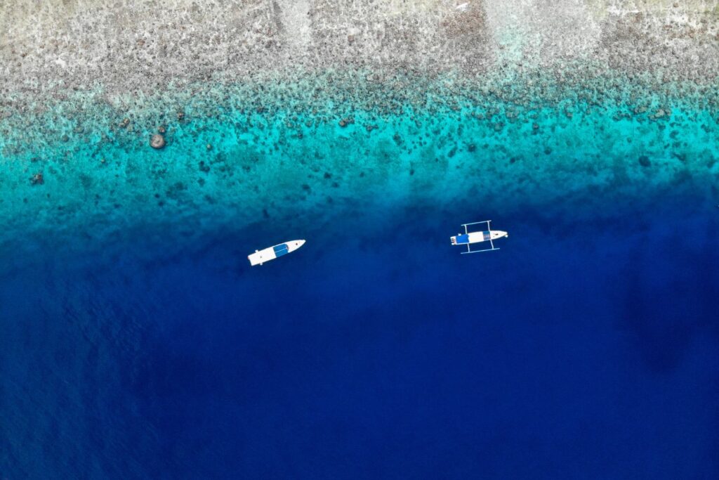 aerial view of two boats on the blue sea of Gili Air