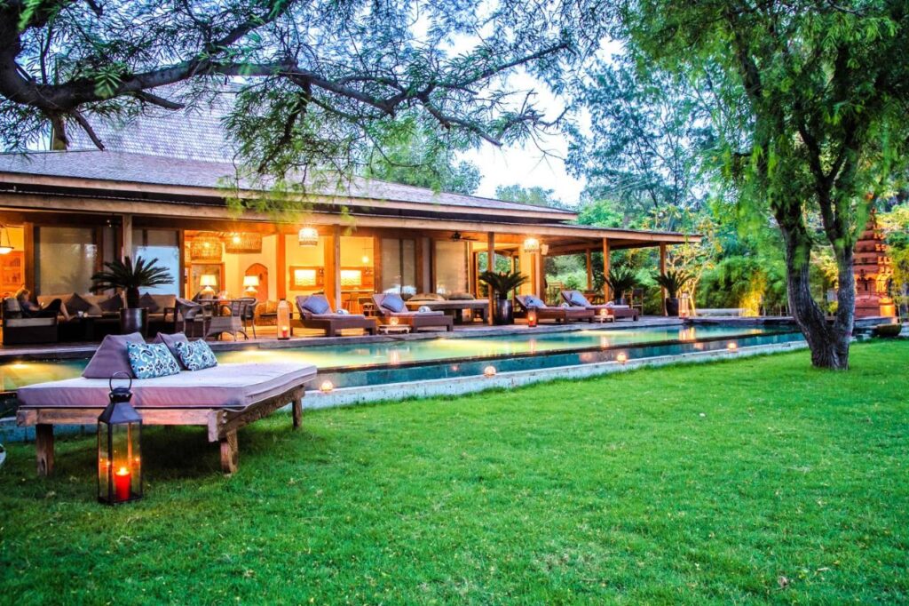 cozy villa with an elegant infinity pool at the front and a garden