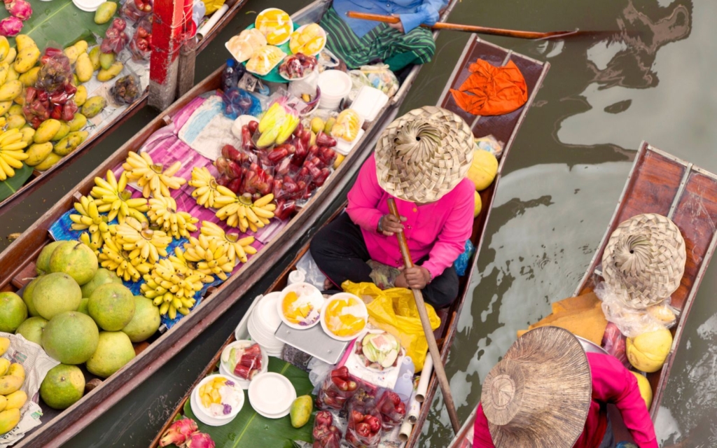 Woman selling food in a famous Thai floating markets, a must-do tourist activity in Thailand