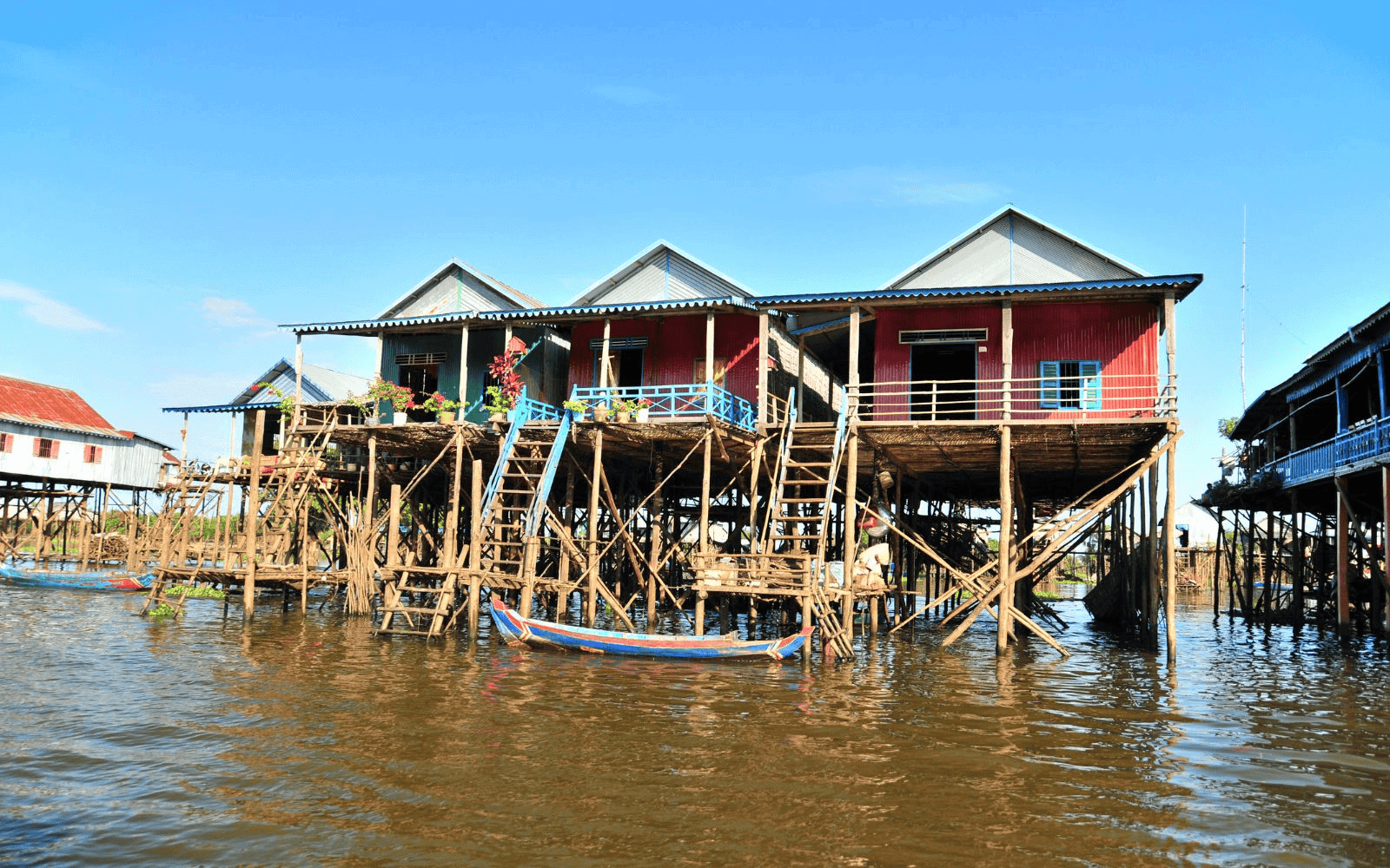 Houses on stilts in the floating villages at Tonlé Sap Lake with boat out front