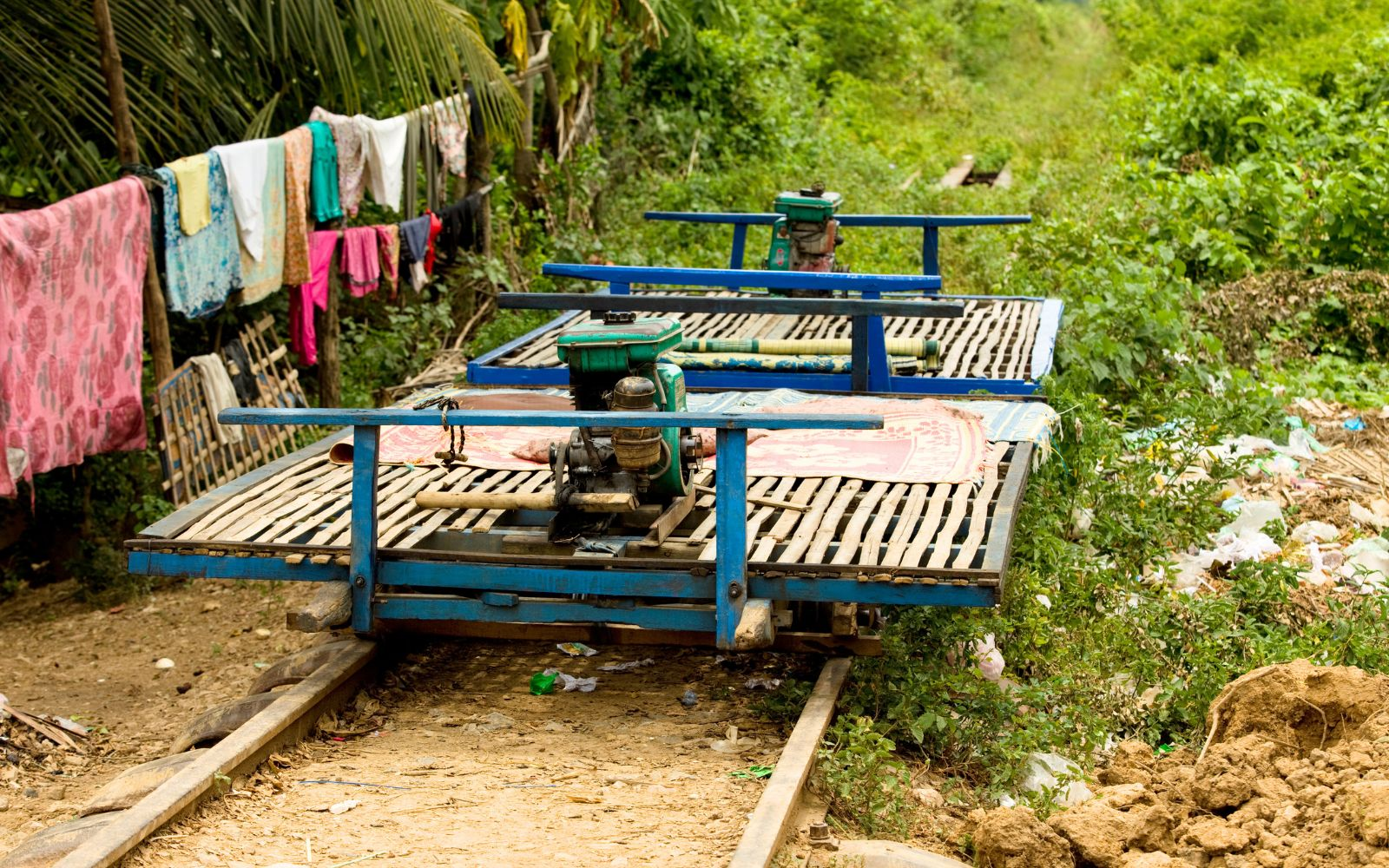 Famous bamboo train in Battambang Cambodia on an overgrown track with greenery